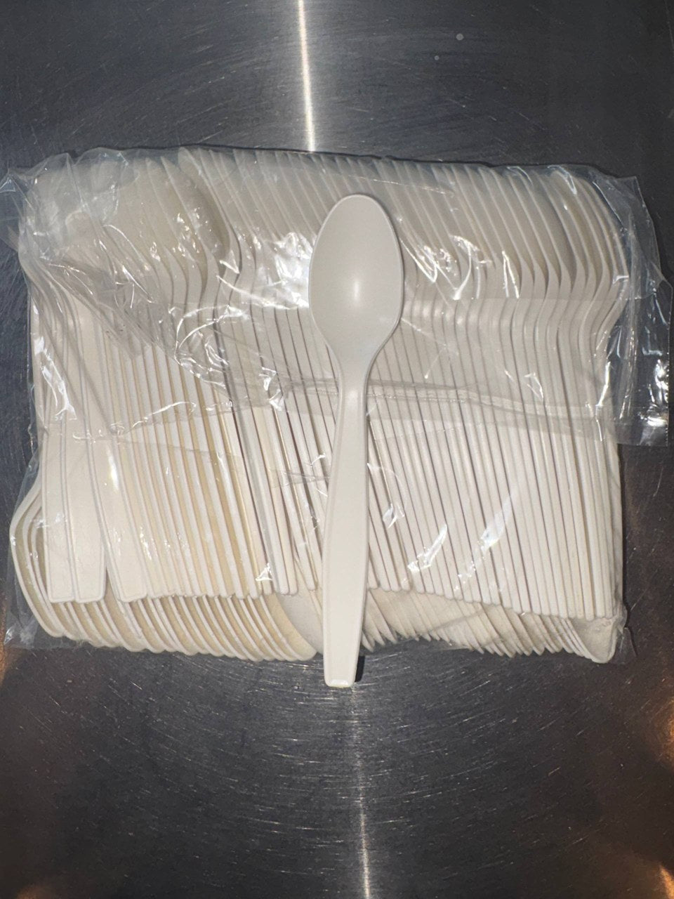 An actual spoon resting on a bag of our spoon stock